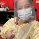 Healthcare worker wearing PPE giving thumbs up